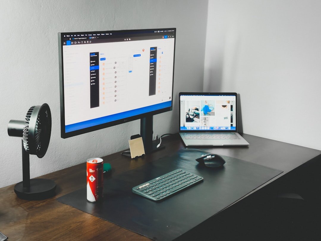 Person working at a laptop with notebook and digital devices on clean desk